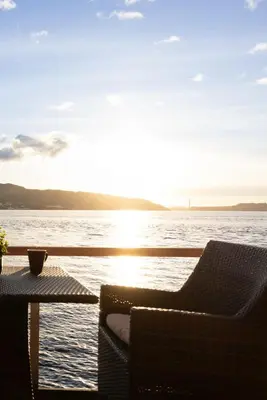 a table and chairs on a balcony with a view of the water at Heimby Homes - Balcony above the sea in Bergen
