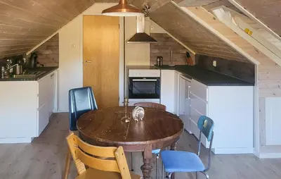 a kitchen with a wooden table and chairs at 1 Bedroom Amazing Apartment In Stord in Stord