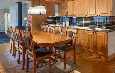 a kitchen with a wooden table and wooden chairs at 3 Bedroom Amazing Home In Haddal in Haddal