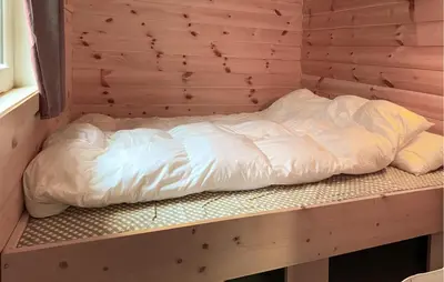 an unmade bed in a wooden room at 3 Bedroom Amazing Home In Haddal in Haddal