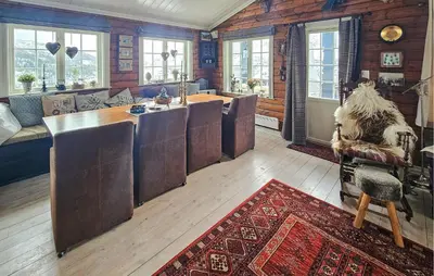 a living room with a table and chairs and windows at Nice Home In Rjukan With Wifi in Rjukan
