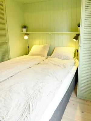 a large white bed sitting in a room at Cabin By Lake Tyrifjorden With Water Views