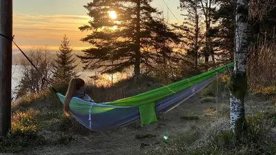 a woman laying in a hammock in a field at Modern Suites, Excellent Location in the heart of Bergen in Bergen
