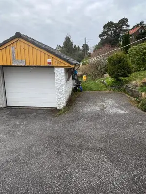 a garage with a yellow roof and white garage doors at Utsiken in Bergen
