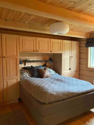 a bedroom with a large bed with wooden cabinets at Traditional mountain cabin in Valdres in Blomstølen