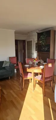 a living room with a wooden table and chairs at Midt i byn in Bergen