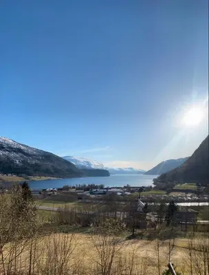 a view of a lake with mountains and a town at Leiligheit i Hornindal in Volda