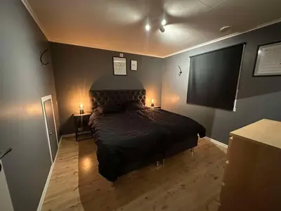 a bedroom with a bed and a flat screen tv at Leiligheit i Hornindal in Volda