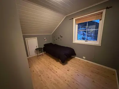 an empty bedroom with a bed and a window at Leiligheit i Hornindal in Volda