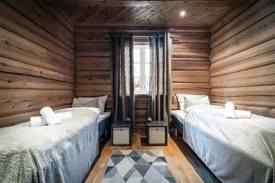 two beds in a room with wooden walls at Vacation house in Hemsedal in Hemsedal