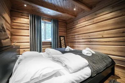 a bedroom with wooden walls and a bed with white pillows at Vacation house in Hemsedal in Hemsedal