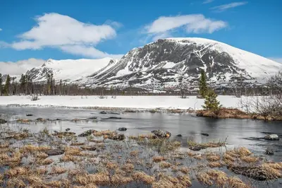a snow covered mountain in front of a river at Vacation house in Hemsedal in Hemsedal