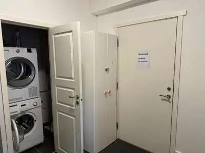 a laundry room with a washer and dryer next to a door at Sentral fantastisk leilighet in Øvre Årdal