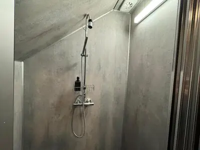 a shower with a shower head in a bathroom at Sentral fantastisk leilighet in Øvre Årdal