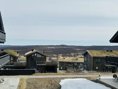 a group of buildings with mountains in the background at Fully equipped ski-in ski-out apartment at Kikut, Geilo in Geilo