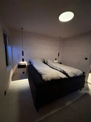 a bedroom with a bed with two lights on it at Modern Cabin With A Personal Touch in Sogndal