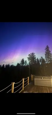 a wooden deck with a fence and trees at night at Veltelia Resort in Nes i Ådal