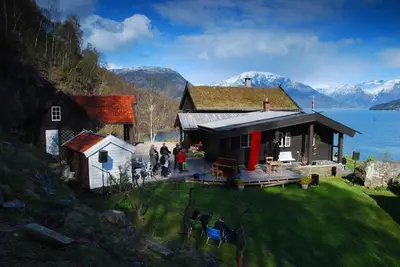 a group of people standing outside of a house at Charming guest house with amazing view in Kvam