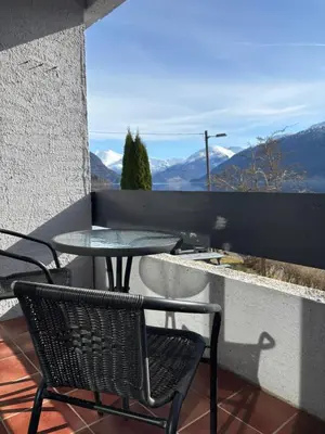 a table and chairs on a balcony with a view of mountains at Faleide View in Stryn