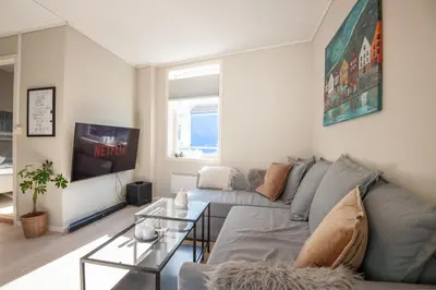 a living room with a couch and a tv at 200 meters to Bryggen in charming Sandviken in Bergen