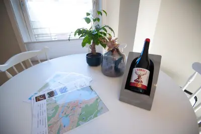 a table with a bottle of wine and a map at 200 meters to Bryggen in charming Sandviken in Bergen