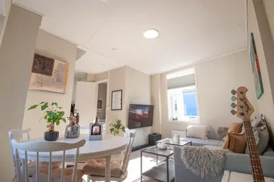 a living room with a table and a guitar at 200 meters to Bryggen in charming Sandviken in Bergen