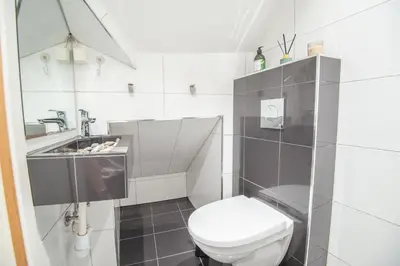 a white bathroom with a toilet and a sink at 200 meters to Bryggen in charming Sandviken in Bergen