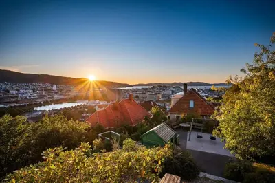 a view of a city with the sun setting at Stay Panorama - Best view in Bergen l Studio in Bergen