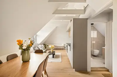 a dining room and living room with white walls and a table at Stay Panorama - Best view in Bergen l 2-Bedroom in Bergen