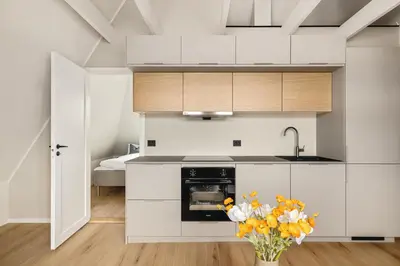 a kitchen with white cabinets and a vase of flowers at Stay Panorama - Best view in Bergen l 2-Bedroom in Bergen