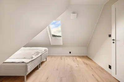 an attic bedroom with a bed and a window at Stay Panorama - Best view in Bergen l 2-Bedroom in Bergen