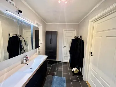a bathroom with a sink and a large mirror at Scenic Private House Surrounded by Nature in Sæbø