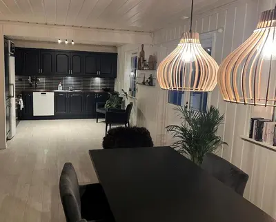 a living room with a table and a kitchen at Scenic Private House Surrounded by Nature in Sæbø
