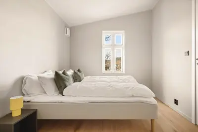 a white bedroom with a bed with white walls at Stay Panorama - Best view in Bergen l 2BR & Terrace in Bergen