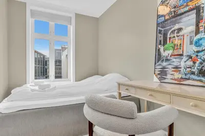 a bedroom with a bed and a desk and a chair at Urban Elegant Apartment in Bergen