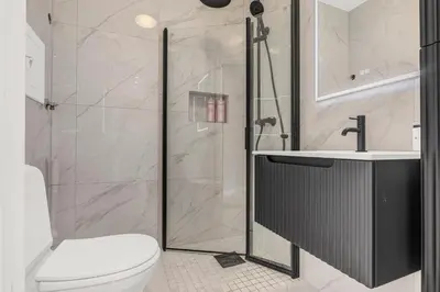 a bathroom with a shower and a toilet and a sink at Urban Elegant Apartment in Bergen
