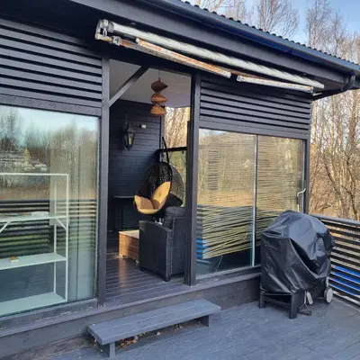 a screened in porch with windows and a bench at Modern holiday home in Ålesund
