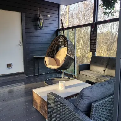 a porch with a hanging chair and a table at Modern holiday home in Ålesund