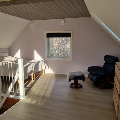 a bedroom with a bed and a chair and a window at Modern holiday home in Ålesund
