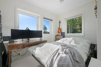 a bedroom with a bed and a desk with a television at Beachfront Villa with Jacuzzi, Cinema & Canoe in Bergen