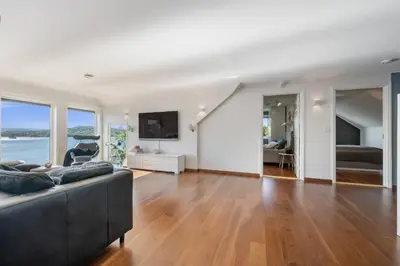 a living room with a couch and a television at Beachfront Villa with Jacuzzi, Cinema & Canoe in Bergen