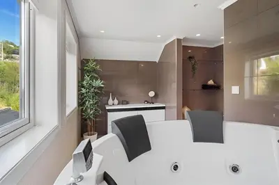 a kitchen with a white table and two chairs at Beachfront Villa with Jacuzzi, Cinema & Canoe in Bergen