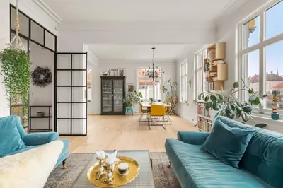 a living room with blue couches and a table at Historic Townhouse I With Rooftop & Free Parking in Bergen