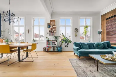a living room with a blue couch and a table at Historic Townhouse I With Rooftop & Free Parking in Bergen