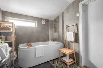 a bathroom with a white tub and a towel rack at Historic Townhouse I With Rooftop & Free Parking in Bergen