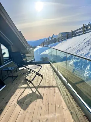 a balcony with two chairs and a snow covered slope at Ski in and ski out in the middle of the slopes in Favang