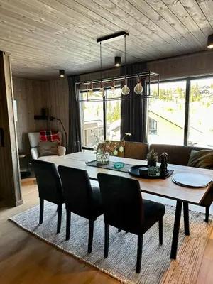 a dining room table and chairs in a living room at Ski in and ski out in the middle of the slopes in Favang