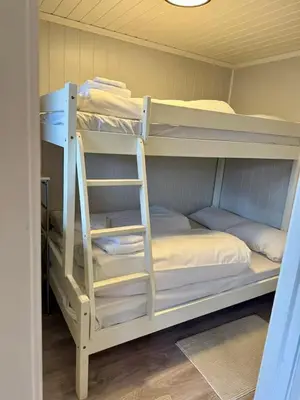 two bunk beds with a ladder in a room at Leilighet i under etasje in Lillehammer