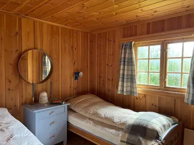 a bedroom with a bed and a mirror and a window at Authentic Norwegian chalet for 8 with fireplaces & modern comfort near Geilo ski slopes in Geilo