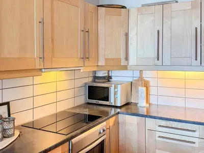 a kitchen with wooden cabinets and a microwave at 4 star holiday home in HOVDEN in Hovden